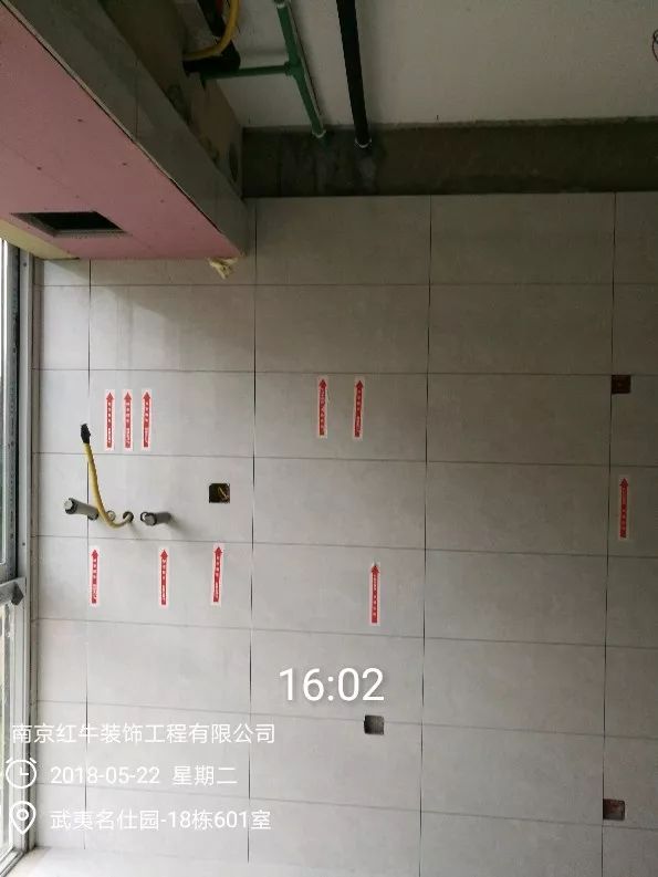 南京武夷名仕園124平米簡美風(fēng)格裝修  享受家?guī)淼臏囟?0五月份_墻磚鋪貼完成后，紅牛裝飾的工人會用專用護(hù)角條對瓷磚角保護(hù)，用標(biāo)貼標(biāo)出水管、線管走向示意。